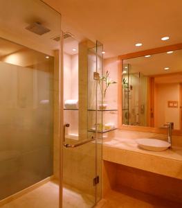 a bathroom with a glass shower and a sink at Lemon Tree Hotel, Banjara Hills, Hyderabad in Hyderabad