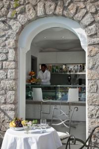 a table with a bowl of fruit and a chef in the kitchen at Hotel La Floridiana in Capri