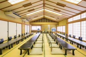 Habitación grande con hileras de mesas y sillas en Kaike Fuga en Yonago