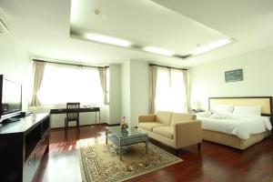 a bedroom with a bed and a couch and a table at The Park 304 Executive Serviced Apartment in Si Maha Phot