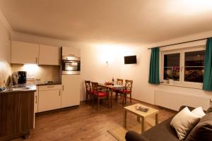 a living room with a kitchen and a table with chairs at Appartement Haus Pichler in Leogang