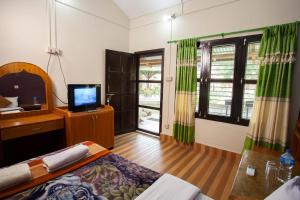 a room with a bed and a television in a room at Sauraha Resort in Sauraha