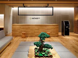 a bonsai tree sitting on a table in a lobby at HATAGO INN Kansai Airport in Izumi-Sano