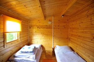 a room with two beds in a wooden room at Domki Rybka in Sarbinowo