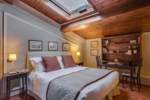 a bedroom with a bed and a desk and a skylight at Locanda Dei Guelfi in Florence