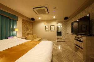 Hotel Waltz Chiryu (Adult Only) في Chiryu: غرفة فندقية بسرير وتلفزيون بشاشة مسطحة