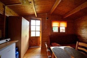 a room with a table and chairs in a cabin at Domki Rybka in Sarbinowo