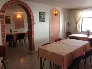 a dining room with tables and chairs and an archway at Pension Casa Alba in Slănic-Moldova