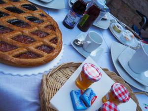 a table with a waffle and a basket of honey at Romantico B&B in Serra SantʼAbbondio