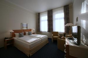 um quarto de hotel com uma cama e uma televisão em Hotel Gutenberg em Westerland