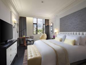 سرير أو أسرّة في غرفة في Golden Tulip New Asia Hotel The Bund Shanghai