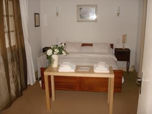 - une chambre avec un lit et une table fleurie dans l'établissement Relais du Château, à Saint-Blancard