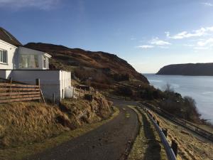 una casa sul fianco di una collina vicino all'oceano di Sealoch Cottage a Breasclete