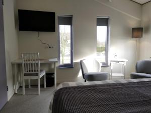 ein Schlafzimmer mit Bett, Schreibtisch und Stühlen in der Unterkunft Antonius Hoeve in Oudenbosch