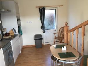 eine Küche und ein Esszimmer mit einem Tisch und einem Fenster in der Unterkunft Sealoch Cottage in Breasclete