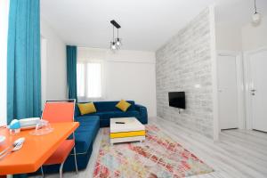 a living room with a blue couch and a tv at Talas Loft Residence in Kayseri