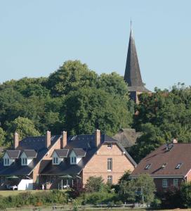 a group of houses and a church with a steeple at Landhaus am Goor in Putbus +8 photos
