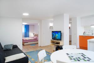 uma sala de estar com uma mesa e uma sala de estar em Apartments Your Colourful Ljubljana Home em Ljubljana