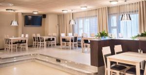 a dining room with tables and chairs and a tv at Hotelli Seurahovi in Porvoo