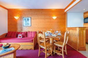 Mâcot La Plagneにあるtravelski home select - Résidence Aspen 4 étoilesのテーブルとベッドが備わる木造の部屋