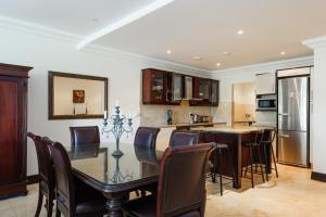 a kitchen and dining room with a glass table and chairs at Ballito Manor Gardens 303 - With Generator in Ballito
