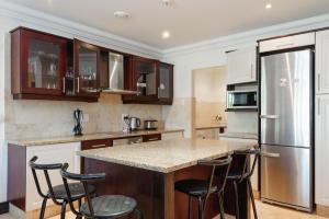 a kitchen with a large island with bar stools at Ballito Manor Gardens 303 - With Generator in Ballito
