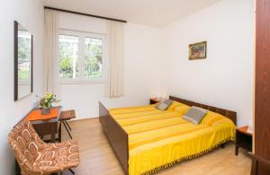 a bedroom with a large yellow bed in a room at Apartment Marko in Brsečine