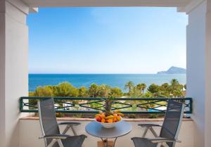 a table with a bowl of fruit on a balcony with the ocean at SH Villa Gadea in Altea