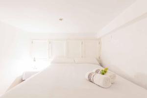 - une chambre blanche avec un lit blanc et 2 serviettes dans l'établissement Apartamento San Marco/Enladrillada, à Séville