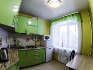 ペルミにあるApartments on Lenina 72Bの小さなキッチン(緑のキャビネット付)、窓