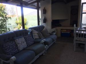 a living room with a blue couch and some windows at 77 ON 7th Street in Hermanus