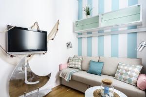 a living room with a couch and a tv on a wall at Apartament Mini with balcony in Sopot