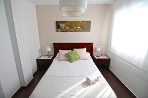 エル・カンページョにあるApartamento Playa Campelloのベッドルーム1室(白いシーツ付きのベッド1台、窓付)