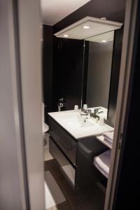 y baño con lavabo blanco y espejo. en The Originals City, Le Cottage Hôtel, Bruay-la-Buissière (Inter-Hotel), en Labuissière