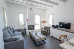 a living room with a couch and a table and a tv at THOAS Residences in Moúdhros