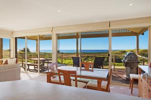 a dining room with a view of the ocean at Beach Breakers Apartment Stunning Views in Kianga