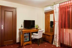 a room with a desk with a television and a chair at Red Hotel in Alexandria