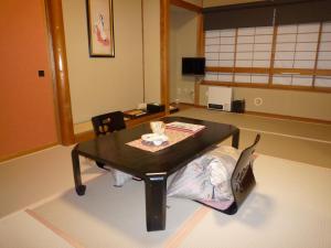 a room with a table and chairs in a room at Yudanaka Tawaraya Ryokan in Yamanouchi