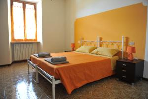 a bedroom with a large bed with an orange blanket at Appartamento Al Ponte in Marone