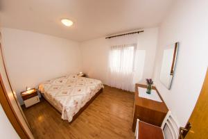 a bedroom with a bed and a wooden floor at House Lucija in Sali