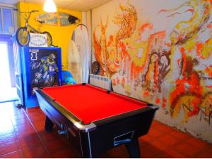 um quarto com uma mesa de bilhar em frente a uma parede em The Paintshop Hostel na Figueira da Foz