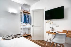 een slaapkamer met een bed, een bureau en een televisie bij Caruso 6 in Sorrento