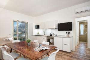 a kitchen and dining room with a wooden table and chairs at Caruso 6 in Sorrento