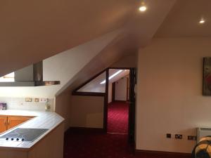 an attic kitchen with a staircase leading to a door at Riverside apartments Westport in Westport