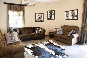 a living room with two couches and a rug at Bush Lovers Lodge in Modimolle