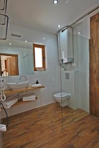 a bathroom with a sink and a toilet and a shower at Osada domków Baca in Poronin