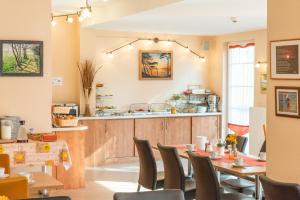 a restaurant with a counter and a table and chairs at Ostseehotel Rike in Wismar