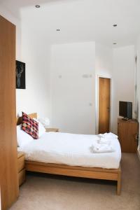 1 dormitorio con 1 cama con sábanas blancas y TV en Four Princes Dock, en Hull