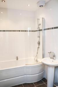 La salle de bains blanche est pourvue d'une baignoire et d'un lavabo. dans l'établissement Four Princes Dock, à Hull