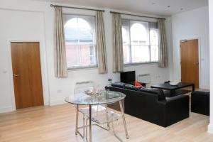 a living room with a black couch and a glass table at Four Princes Dock in Hull